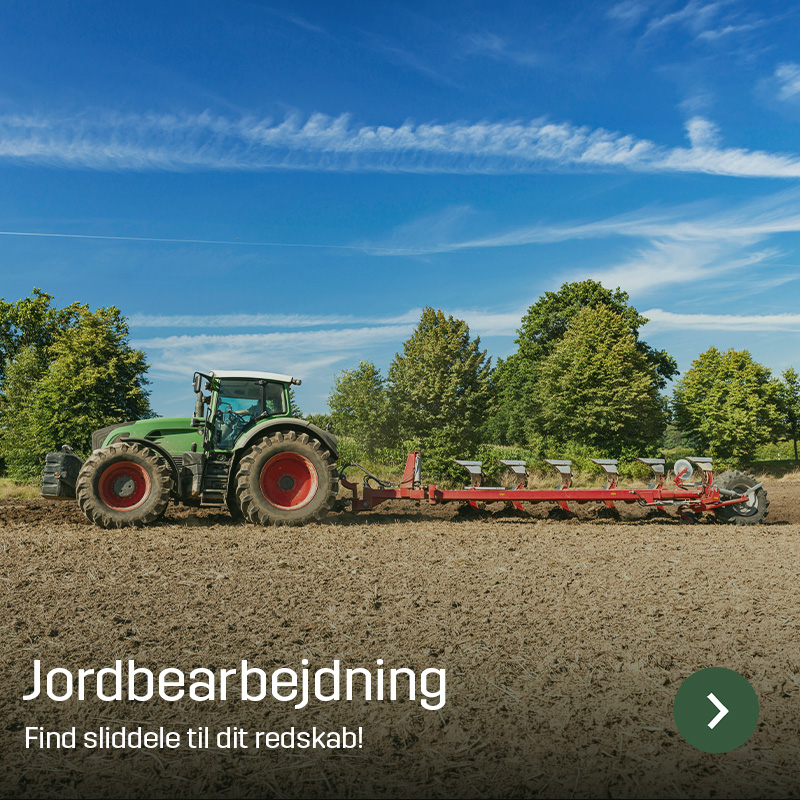 Traktor med plov arbejder på mark og vender jorden i lange træk med træer i baggrunden. Sagros sliddele bruges i jordbearbejdningsredskaber til effektiv bearbejdning før såning.