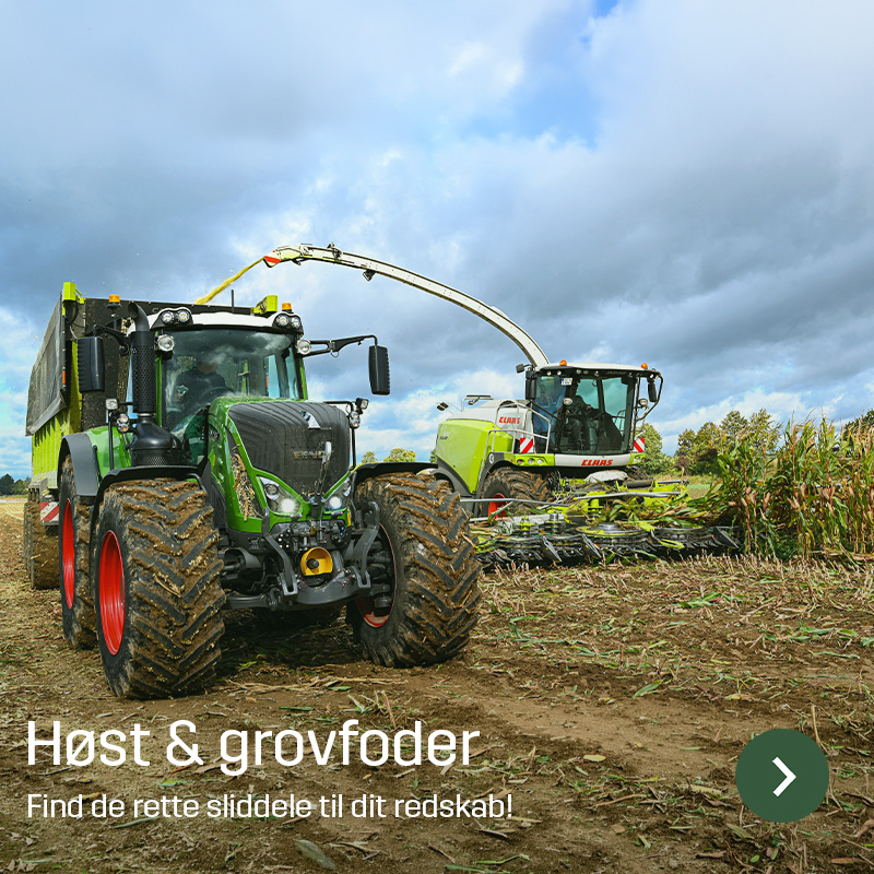 Traktor med vogn kører ved siden af en selvkørende finsnitter, der høster majs og blæser materialet over i vognen. Billedet viser grovfoderhøst i marken med maskiner, som Sagros tilbyder sliddele og reservedele til