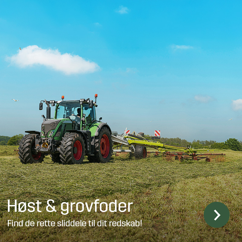 Traktor med river arbejder på høstet mark under klar himmel. Sagros sliddele og reservedele til grovfoderhøst og markmaskiner vises i brug på landbrugsmaskine.