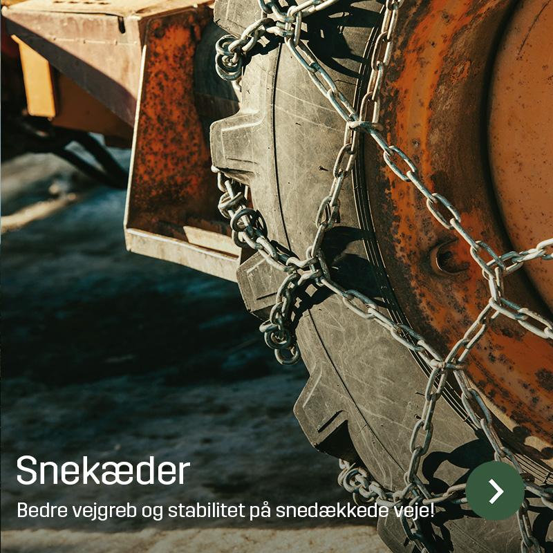 Nærbillede af snekæder monteret på et traktordæk med orange fælg. Kæderne går på tværs af dækkets slidbane for bedre vejgreb på sne og is. Sagros sortiment omfatter snekæder til landbrugsmaskiner.